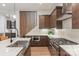 Modern kitchen featuring stainless steel appliances, dark wood cabinets, and a large island with a farmhouse sink at 4108 Commonwealth Ave, Charlotte, NC 28205