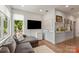 Bright living area with a comfortable gray sofa, modern TV, and gallery shelves for displaying artwork at 4108 Commonwealth Ave, Charlotte, NC 28205