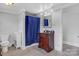 Bathroom features a wood cabinet, neutral walls, tile flooring and a shower with blue curtain at 4335 E Nc 10 Hwy, Claremont, NC 28610