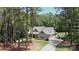 Secluded home nestled among tall trees, featuring a long driveway and an attached garage at 4660 Gold Finch Dr, Denver, NC 28037
