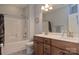 Bathroom features a bathtub with shower and double-sink vanity with wood cabinets at 4660 Gold Finch Dr, Denver, NC 28037