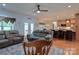 Open-concept living room with hardwood floors, a stone fireplace, and seamless access to the kitchen at 4660 Gold Finch Dr, Denver, NC 28037