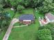 Aerial view of a brick home with a pool, large yard, mature trees, and outbuildings in a residential neighborhood at 5633 Mallard S Dr, Charlotte, NC 28227