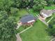 Aerial view of a brick home with a large yard, mature trees, and outbuildings in a residential neighborhood at 5633 Mallard S Dr, Charlotte, NC 28227