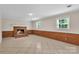 Finished basement featuring brick accent wall, neutral paint, and tiled floor at 5633 Mallard S Dr, Charlotte, NC 28227