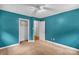 A bright bedroom with blue walls, ceiling fan, closet, and soft carpeting at 5633 Mallard S Dr, Charlotte, NC 28227