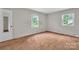 A serene bedroom with neutral walls, plush carpeting, and two windows offering natural light at 5633 Mallard S Dr, Charlotte, NC 28227