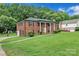 Brick home featuring an attached garage, well-kept lawn, and mature trees at 5633 Mallard S Dr, Charlotte, NC 28227