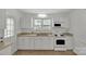 Bright kitchen featuring white cabinets, stainless steel sink, and modern appliances at 5633 Mallard S Dr, Charlotte, NC 28227