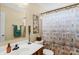 Well-lit bathroom with a vanity, toilet, and bathtub featuring a decorative shower curtain at 6104 Follow The Trl, Indian Trail, NC 28079