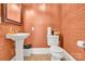Powder room featuring a white pedestal sink and toilet with brick-patterned walls at 634 E Center Ave, Mooresville, NC 28115