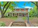 Inviting two-story brick home with a full front porch, complemented by mature trees and lush landscaping at 634 E Center Ave, Mooresville, NC 28115