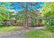 Side view of a classic brick home with a covered porch and mature landscaping for added privacy at 634 E Center Ave, Mooresville, NC 28115