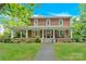 Charming two-story brick home featuring a welcoming front porch with classic columns and a beautifully landscaped yard at 634 E Center Ave, Mooresville, NC 28115
