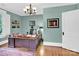 This is an office with neutral paint, dark wood furniture, hardwood floors, and a ceiling fan at 634 E Center Ave, Mooresville, NC 28115