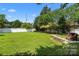 Expansive backyard featuring lush green grass, a brick firepit area, and a white privacy fence at 6614 Truman St, Indian Trail, NC 28079