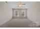 Large carpeted bedroom with two windows, tray ceiling and neutral color palette at 6614 Truman St, Indian Trail, NC 28079