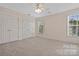 Neutral bedroom featuring plush carpeting, dual closets, and window providing natural light at 6614 Truman St, Indian Trail, NC 28079