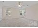 Spacious bedroom with neutral carpet, great natural light from windows and classic ceiling fan at 6614 Truman St, Indian Trail, NC 28079