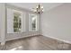 Well-lit dining room with hardwood floors, a modern chandelier, and natural light at 6614 Truman St, Indian Trail, NC 28079