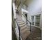 Elegant staircase with carpeted steps, complemented by decorative French doors enhancing the home's architectural charm at 6614 Truman St, Indian Trail, NC 28079