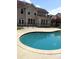 Backyard view showcasing the sparkling in-ground swimming pool surrounded by a concrete patio and black metal fence at 6614 Truman St, Indian Trail, NC 28079