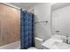 A bathroom with beige tile and shower with a blue curtain at 743 Anderson St, Charlotte, NC 28205