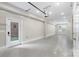 A bright garage with neutral paint, sealed floors, a garage door, service door, and window at 743 Anderson St, Charlotte, NC 28205