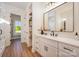 Bright bathroom with a double vanity, modern fixtures, and an open doorway to a sunroom at 919 Village Lake Dr, Monroe, NC 28110