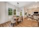 Dining room featuring large windows providing natural light, stylish pendant lighting, and hardwood floors at 919 Village Lake Dr, Monroe, NC 28110
