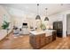 Open concept kitchen featuring modern appliances, a stylish island, and a breakfast bar with hardwood floors at 919 Village Lake Dr, Monroe, NC 28110