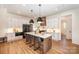 A spacious kitchen with a central island, bar stools, modern appliances, and stylish lighting fixtures at 919 Village Lake Dr, Monroe, NC 28110
