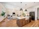 Modern kitchen featuring an island with a sink and pendant lights, open to a living room with a fireplace at 919 Village Lake Dr, Monroe, NC 28110
