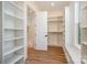Spacious walk-in closet with built-in shelving, a window seat, and an adjacent bathroom with a glass-enclosed shower at 919 Village Lake Dr, Monroe, NC 28110