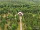Aerial view of a stunning property surrounded by lush forest, showcasing its secluded location and charming red home at 925 Hamilton Rd, Chester, SC 29706