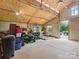 Barn interior with lawn equipment, storage containers, open doorway, and insulated ceilings at 925 Hamilton Rd, Chester, SC 29706