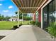 Inviting covered porch with hanging plants and a view of the lush green lawn, tractor, and other barn at 925 Hamilton Rd, Chester, SC 29706