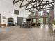 Open-concept living area with high ceilings, wood beams, and modern chandelier, seamlessly connecting dining and seating spaces at 925 Hamilton Rd, Chester, SC 29706