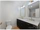 Beautiful bathroom featuring double vanity with marble countertop, dark cabinets and matching mirrors at 9520 Squirrel Hollow Ln, Charlotte, NC 28270
