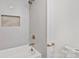 Modern bathroom featuring tiled shower and tub combination with gold hardware and shelving at 9520 Squirrel Hollow Ln, Charlotte, NC 28270