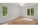 Bright, airy bedroom with hardwood floors and large windows overlooking the green trees outside at 9520 Squirrel Hollow Ln, Charlotte, NC 28270