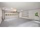Spacious three-car garage featuring shelving and ample storage space, suitable for vehicles and projects at 9520 Squirrel Hollow Ln, Charlotte, NC 28270