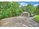 Detached garage with a wide driveway surrounded by a green landscape and forest at 9520 Squirrel Hollow Ln, Charlotte, NC 28270