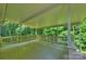 This spacious porch offers a perfect space to unwind with serene views of the surrounding trees and greenery at 9520 Squirrel Hollow Ln, Charlotte, NC 28270