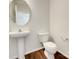 Powder room with pedestal sink, wood flooring, and modern fixtures at 10319 Willingham Rd, Huntersville, NC 28078