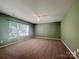 Spacious bedroom with neutral carpet, green walls, a ceiling fan, and a large window at 10319 Willingham Rd, Huntersville, NC 28078