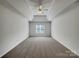 Spacious bedroom featuring tray ceiling, neutral carpet, and a window at 10319 Willingham Rd, Huntersville, NC 28078