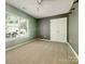 Bedroom featuring neutral carpet, a double door closet, and a window at 10319 Willingham Rd, Huntersville, NC 28078
