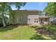 A lush backyard featuring a fire pit, patio with seating, and beautifully landscaped garden beds at 10327 Shelter Rock Ct, Charlotte, NC 28214