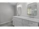 A bathroom features a double sink vanity with modern fixtures and hardware, framed mirrors, and light gray walls at 10327 Shelter Rock Ct, Charlotte, NC 28214